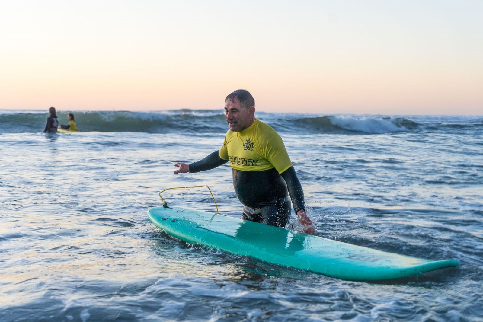An older beginner smiling in waist-deep water